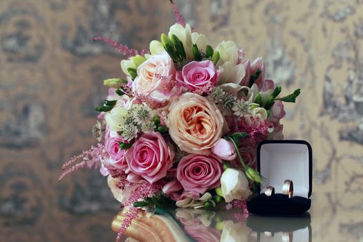 Beautiful wedding bouquet from pink roses and wedding ring