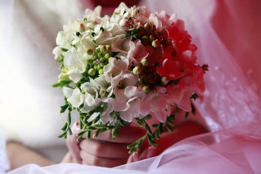 The bride holds a wedding bouquet