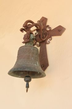An old bell at the wall of a church.