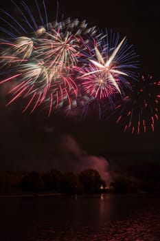 Brightly colorful fireworks and salute of various colors in the night sky background