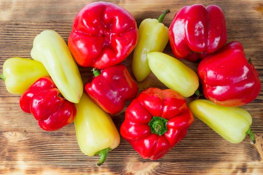 Vegetable still life of mature red and green peppers on wooden background