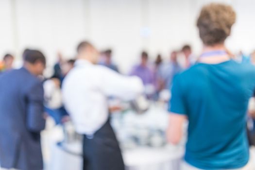 Abstract blurred people socializing during coffee break at business meeting or conference.