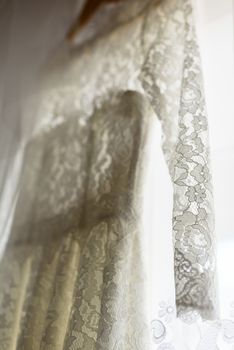 bridesmaid dress hanging on a hanger in front of the window, backlight