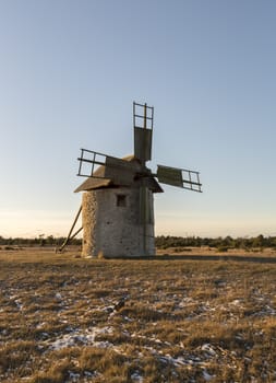 Windmill in Field with grass and snow.
