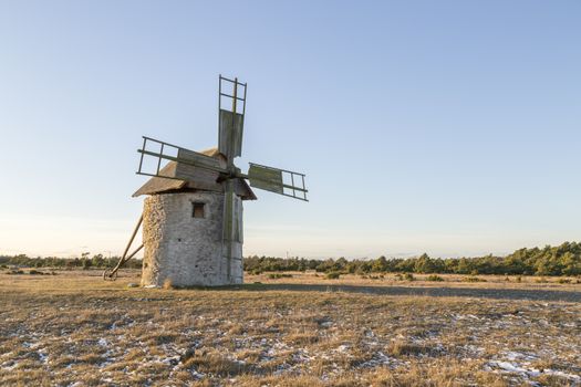 Windmill in Field with grass and snow.