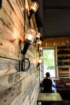 interior wooden cafe with lamps on the wall
