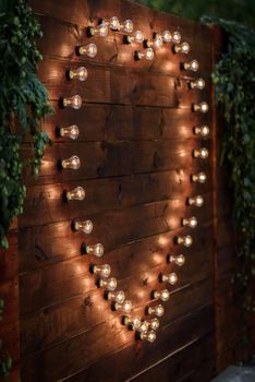 wedding banquet on the background of the heart of the lamps in the forest among the trees on the green track