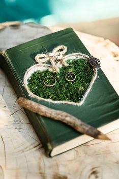 wedding rings on the grass in the stylized book