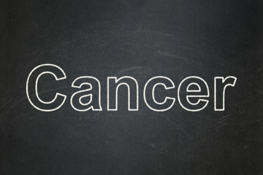 Health concept: text Cancer on Black chalkboard background