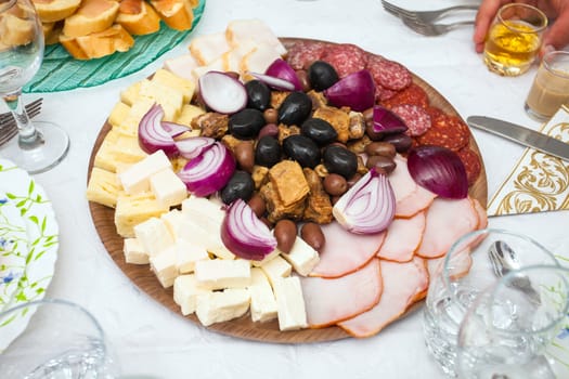 Cocktail food appetizer with ham, salami, red onions, pork chops and a variety of olives and cheeses