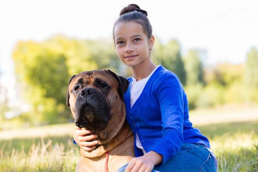 teen girl with the dog Bullmastiff outdoors