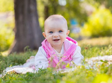 portrait of a smiling baby girl on the grass