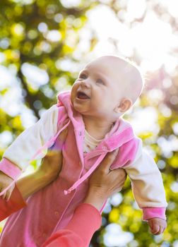 portrait of laughing baby girl on hands