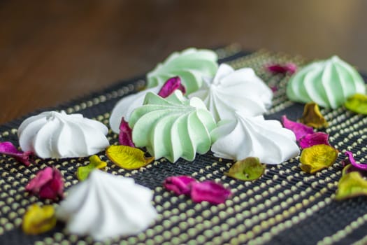 White and green marshmallow dessert composition on black background