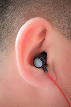 Male human ear with red wire earphone