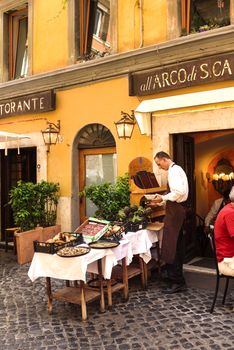 Rome, Italy - May 27, 2016: Unidentified people eating traditional italian food in outdoor restaurant in Trastevere district in Rome, Italy.