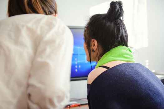 online shopping and technology concept - two girls with computer