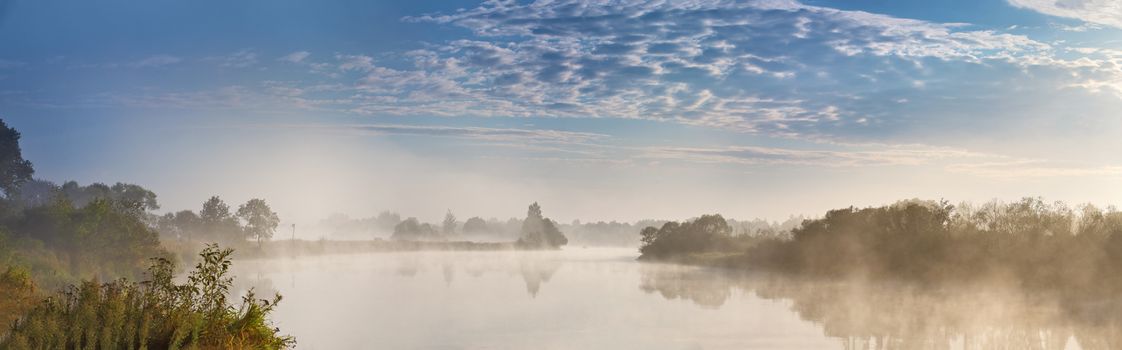 Foggy river in the autumn morning. Panorama