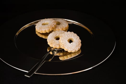 Some biscuits reflected on a silver plate