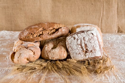 Several kind of loaves with ears of wheat and jute background