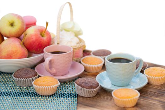 Still life of served coffee cups, macaroon cookies, marshmallows and apples