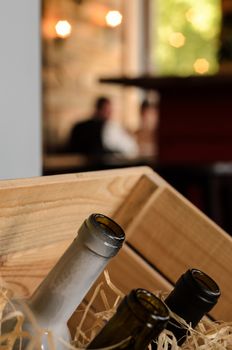 empty wine bottles in a wooden box with hay