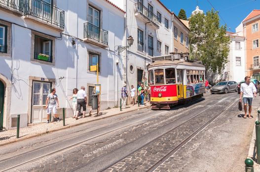 LISBON, PORTUGAL - AUGUST 23: Famous Lisbon tram number 28 on the street of Alfama district on 23 August, 2014 in Lisbon. Trams keep the traditional style of the historic center of Lisbon.