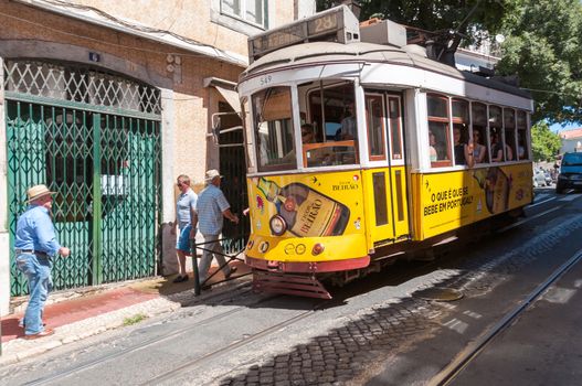 LISBON, PORTUGAL - AUGUST 23: Famous Lisbon tram number 28 on the street of Alfama district on 23 August, 2014 in Lisbon. Trams keep the traditional style of the historic center of Lisbon.