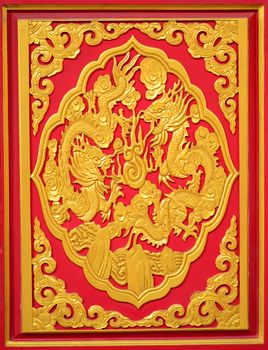 Golden dragon on the red wall of Chinese temple in Thailand