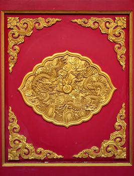 The golden dragon on the red door of Chinese temple in Thailand