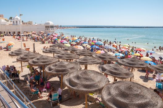 Cadiz, Spain - August 27, 2014: People sunbathing on Caleta Beach, small and very popular beach located in Cadiz city center.