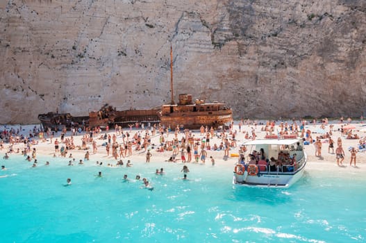 Zakynthos, Greece - August 27, 2015: Crowded Navagio Beach on Zakynthos Island. Famous Navagio Beach is the most popular tourist attraction on the island.