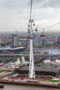 LONDON, UNITED KINGDOM - NOVEMBER 8, 2014:  Gondolas of the Emirates Air Line cable car in London on a rainy day. Thames cable car is a ten minute gondola lift link across the River Thames.