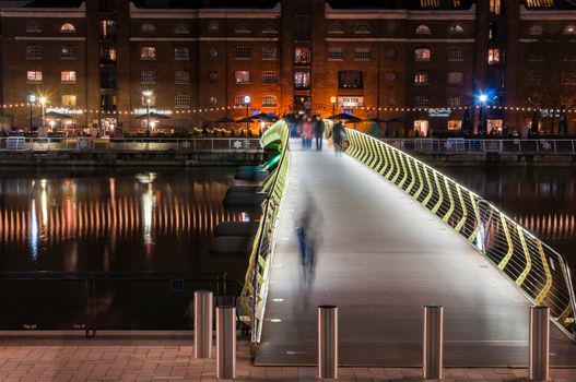 LONDON, UNITED KINGDOM - NOVEMBER 10, 2014: Illuminated foot bridge in over North Dock in Canary Wharf by night