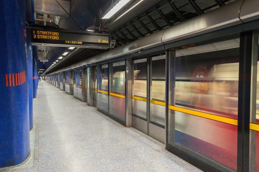 LONDON, UNITED KINGDOM - NOVEMBER 8, 2014: Jubilee line train leaves modern North Greenwich station. The Jubilee line is the newest line on the network.