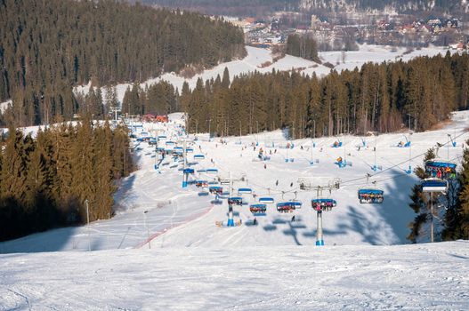 Bialka Tatrzanska, Poland - February 16, 2015: Ski slope and modern chair ski lift called Pasieka Express in Kotelnica Bialczanska Ski Resort in Tatra Mountains on a sunny day