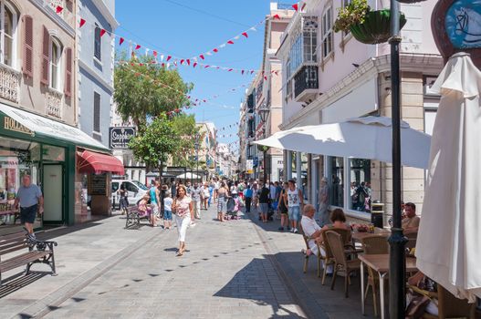 GIBRALTAR - AUGUST 27, 2014: Tourists visit Main Street, the main arterial street in the British overseas territory of Gibraltar.