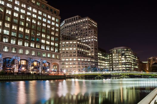 LONDON, UNITED KINGDOM - NOVEMBER 10, 2014: Illuminated modern buildings in North Dock in London's docklands at night. Canary Wharf is one of London's two main financial centres.