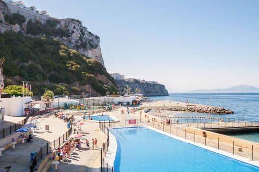 Gibraltar - August 27, 2014: People sunbathe at open |air swimming pool in Gibraltar, Aa very popular spot to take a swim and sunbath with access to the sea.