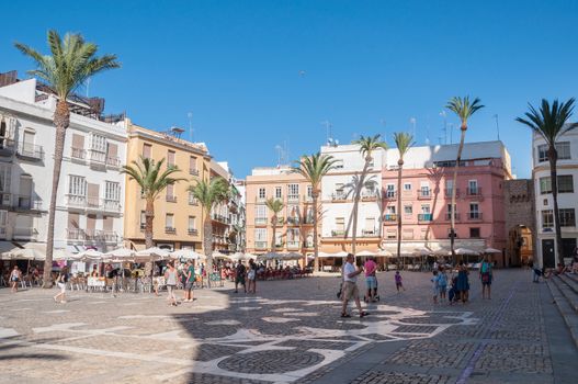 CADIZ, SPAIN - AUGUST 27, 2014: Tourists visit pavement cafes in the Plaza de la Catedral in Cadiz.