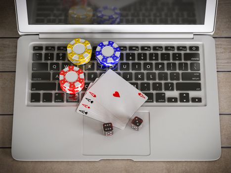 laptop with chips, dices and poker cards on the table
