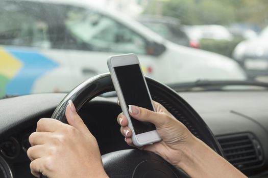 girl with a mobile phone behind the wheel in the saloon car