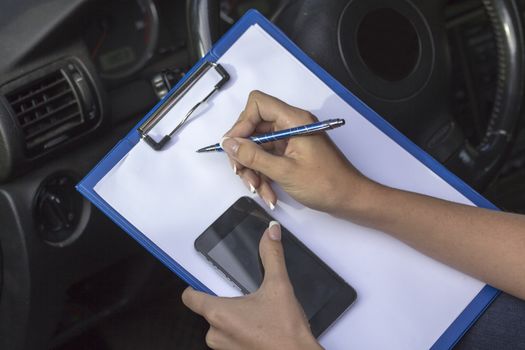 Girls hold hands in the car clip board, pen and telephone