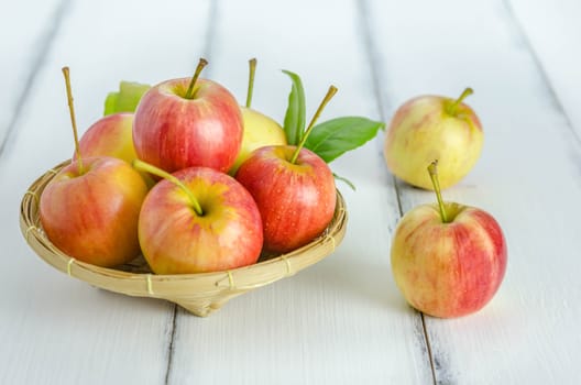 Red and yellow apple  with bamboo basket , organic fresh fruit on white  wooden background