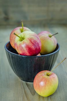 Red and yellow apple with black bowl