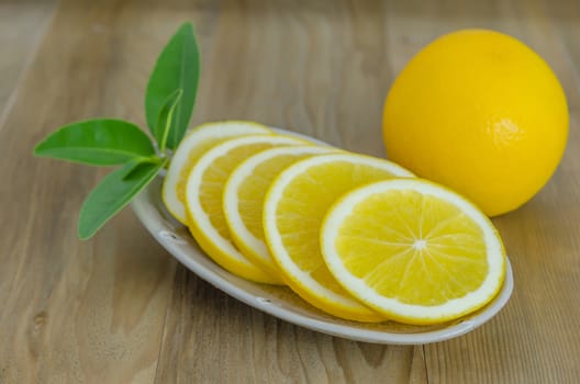 slice orange on dish over wooden background