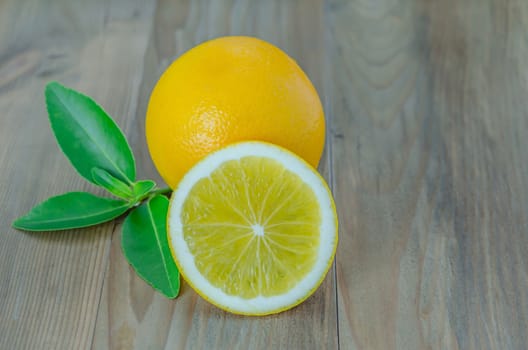 ripe orange with leaves on wooden background