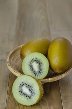 kiwi fruit and sliced with bamboo basket on wooden background