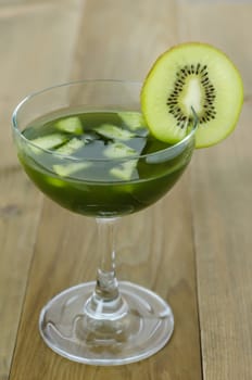 glass of kiwi juice with fresh fruits on wooden table