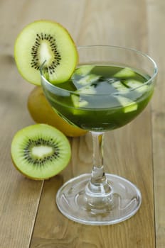 glass of kiwi juice with fresh fruits on wooden table